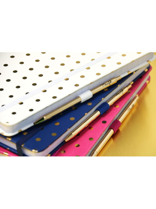 Stack of A5 notebooks with small gold dot covers and matching gold pens in pink, blue, and white.