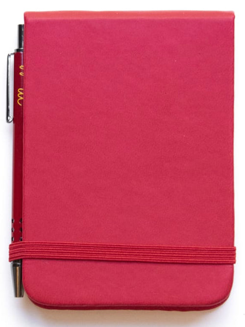 Pocket-sized notebook with soft cover, elastic band closure, and matching metallic ballpoint pen