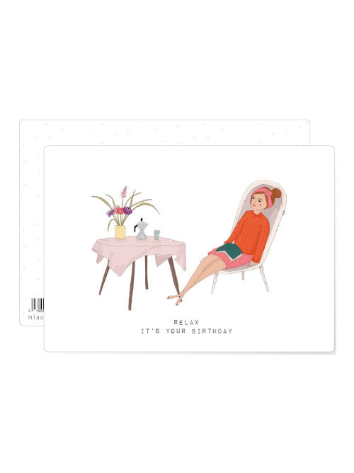 Illustrated birthday postcard showing a relaxed woman reclining beside a small table with coffee and flowers.
