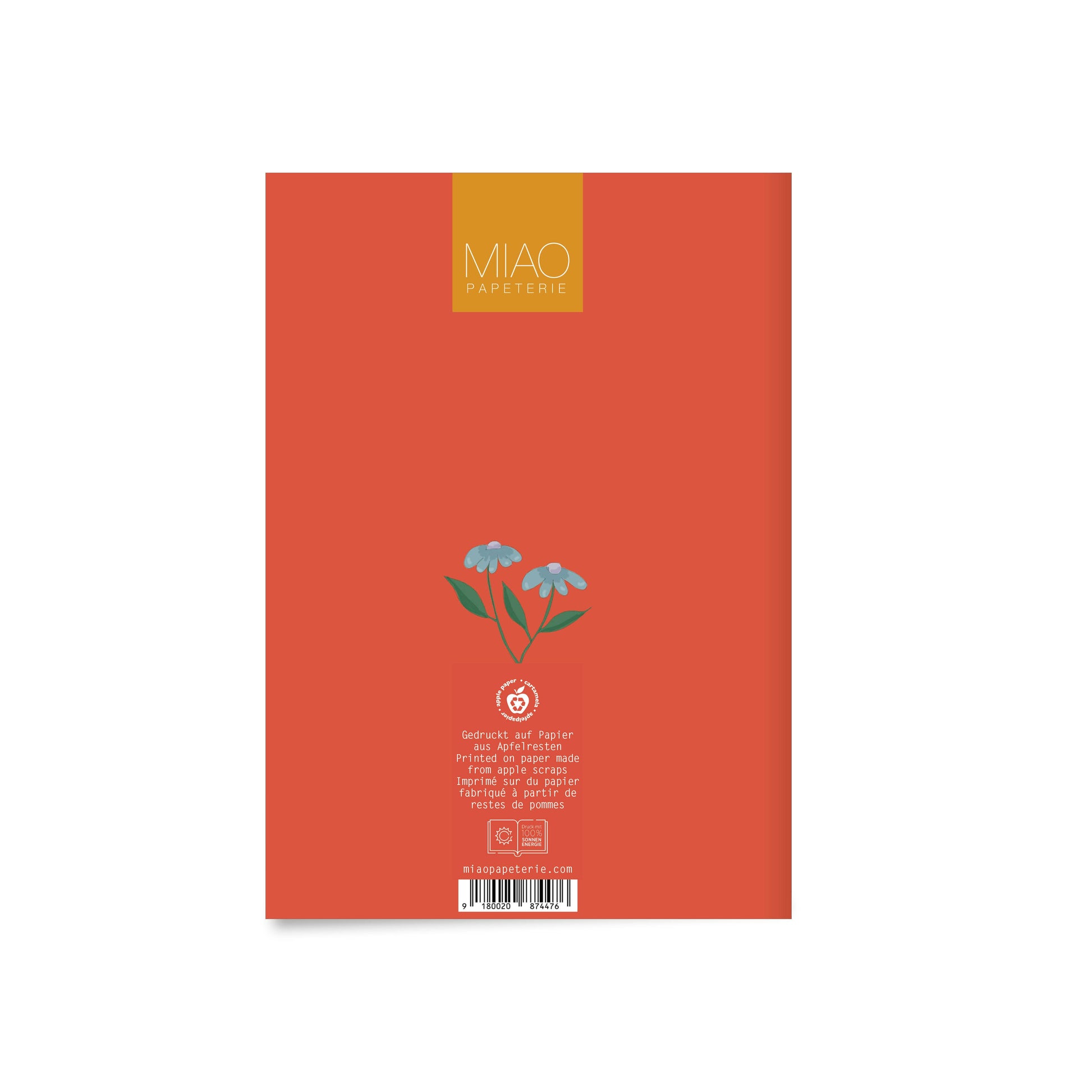 orange notebook back cover with small blue flower illustration, product information text, and barcode at bottom