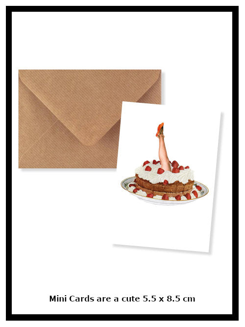 Mini greetings card featuring illustration of a cake with a pair of legs emerging, shown with kraft envelope on white background