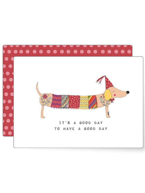 Illustrated dachshund with an elongated colourful patterned body wearing a party hat, creating a playful and cheerful postcard design.