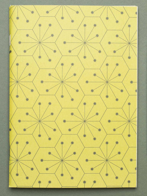 Front cover of lime green softcover notebook with geometric designs tessellating 