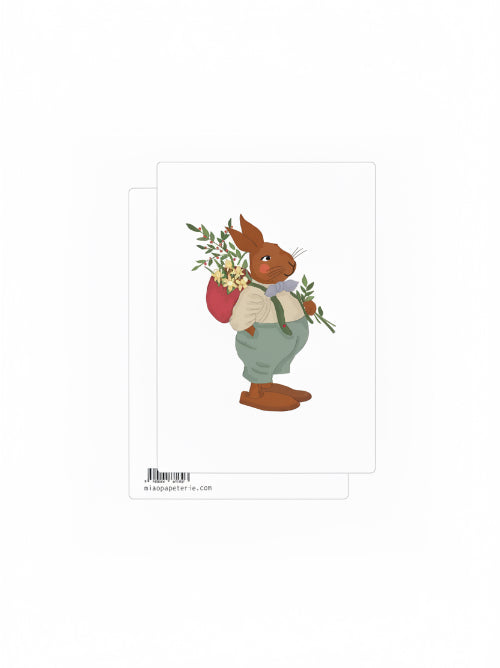 Gentle illustration of a rabbit wearing a bow tie inside an oval frame with Happy Easter text, soft pastel Easter postcard with a whimsical hand drawn style.