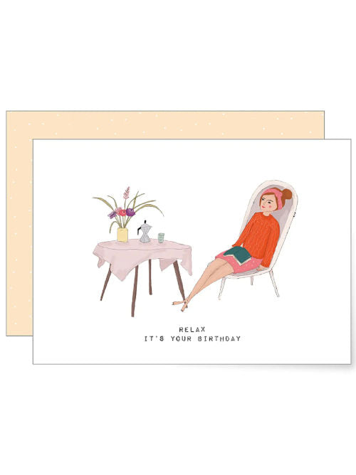Illustrated birthday card showing a relaxed woman reclining beside a small table with coffee and flowers.