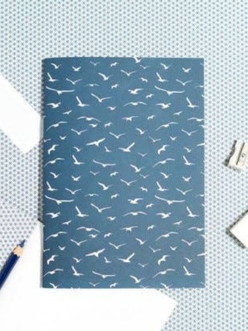 a dark blue softcover notebook covered with white seagulls.