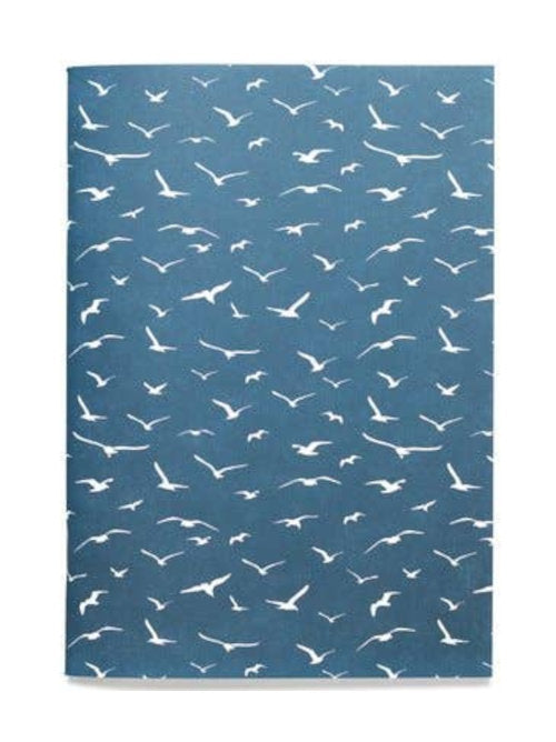 Backside of a softcover notebook that's dark blue and covered in white seagulls