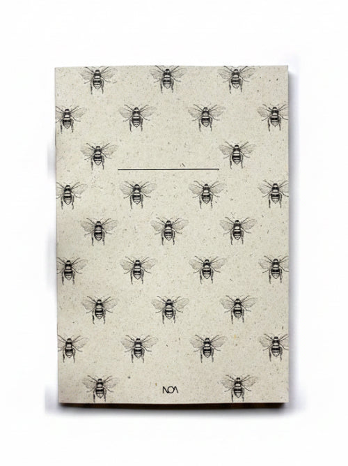 Grass Paper Notebook with bee pattern on a white background.