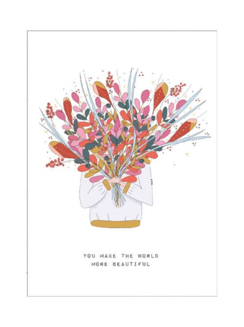 A postcard with a person holding up a huge bunch of flowers obscuring their face. The text says "You make the world more beautiful". Handmade and illustrated in Austria. 