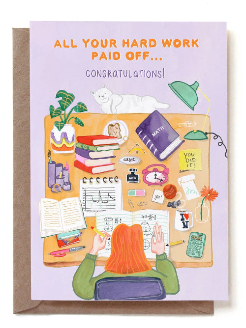 Graduation card with illustration of a person at a desk with text 'All your hard work paid off... Congratulations!'